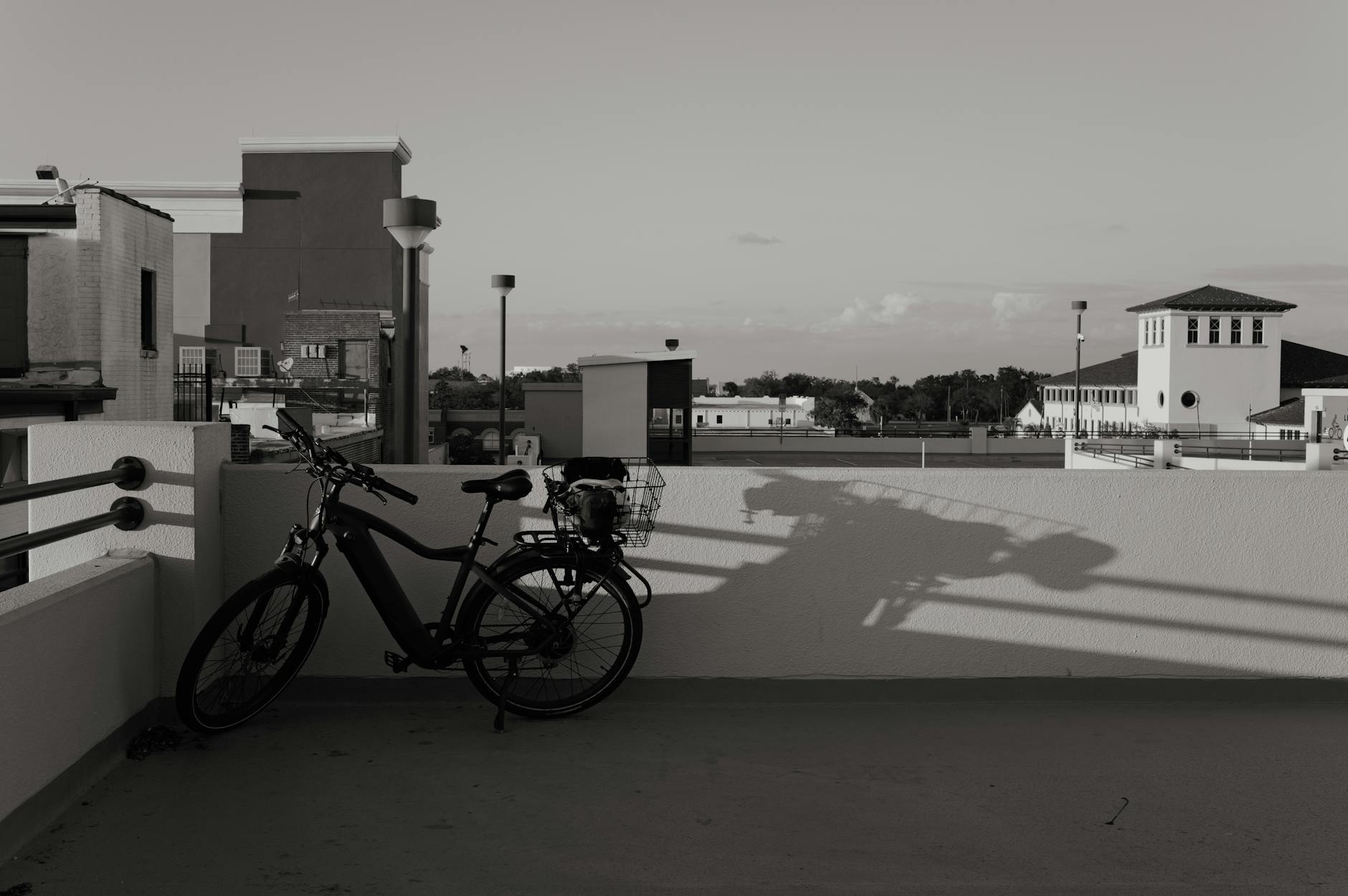 Silhouette eines Fahrrads vor urbaner Skyline bei Dämmerung, moderne Architektur.